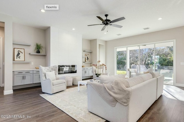 living room with ceiling fan and dark hardwood / wood-style flooring