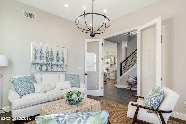 living room featuring dark hardwood / wood-style flooring and an inviting chandelier