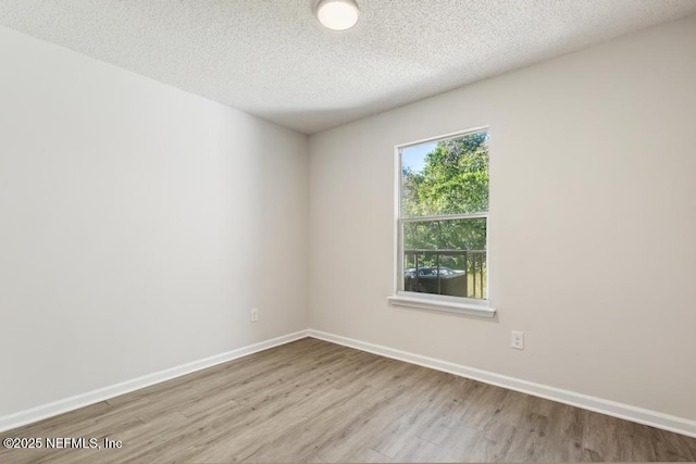 unfurnished room with light hardwood / wood-style flooring and a textured ceiling