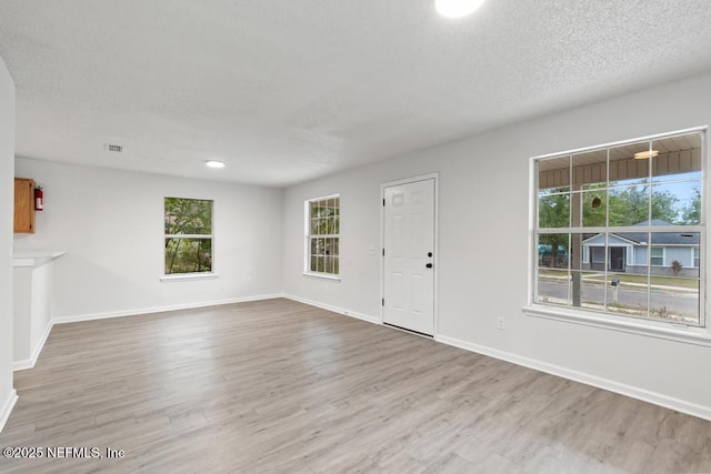 interior space with light hardwood / wood-style flooring and a textured ceiling