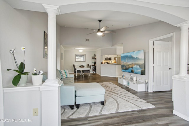 living room with decorative columns, dark hardwood / wood-style flooring, and ceiling fan