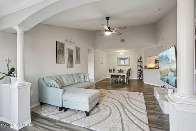 living room with decorative columns, vaulted ceiling, dark hardwood / wood-style floors, and ceiling fan