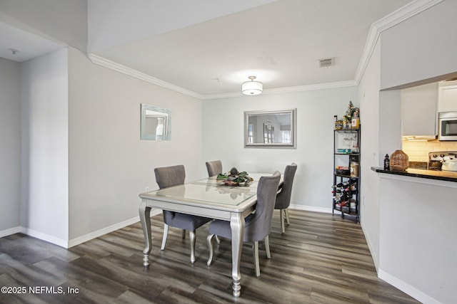 dining space with ornamental molding and dark hardwood / wood-style floors