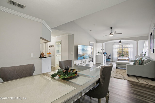 dining room featuring lofted ceiling, crown molding, ceiling fan, hardwood / wood-style floors, and decorative columns