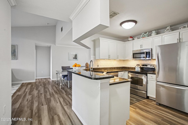 kitchen with sink, stainless steel appliances, white cabinets, kitchen peninsula, and light wood-type flooring