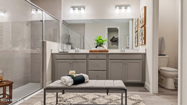 bathroom featuring vanity, toilet, and a shower with shower door