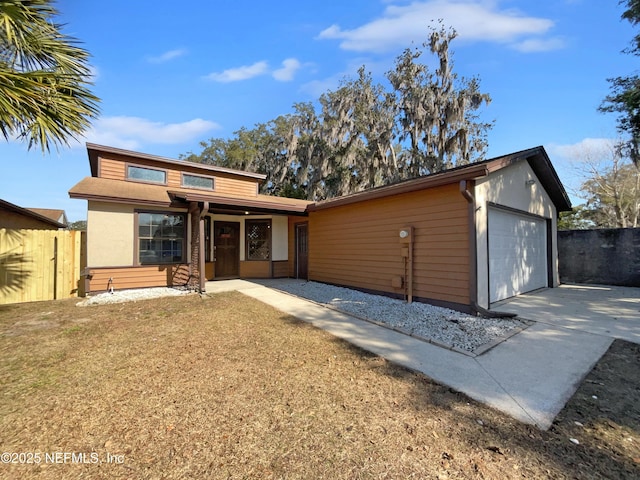 view of front of property featuring a garage and a front lawn