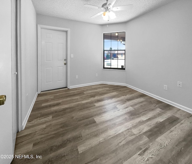 spare room with ceiling fan, dark hardwood / wood-style floors, and a textured ceiling