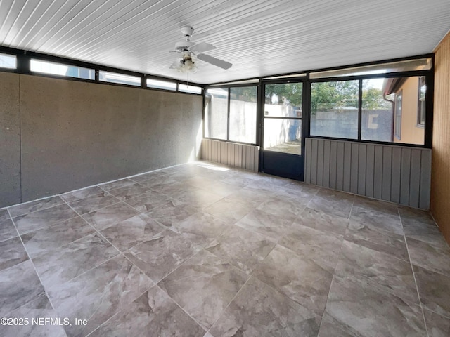 unfurnished sunroom with ceiling fan