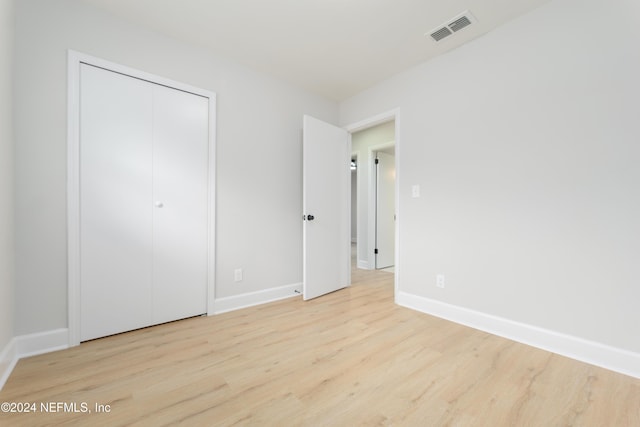 unfurnished bedroom featuring a closet and light wood-type flooring