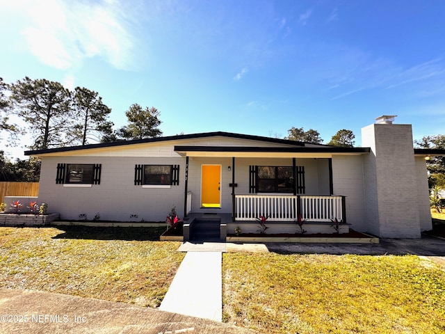 view of front facade with a front yard and covered porch