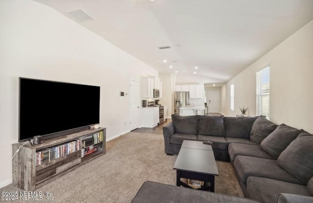 carpeted living room with lofted ceiling, baseboards, visible vents, and recessed lighting