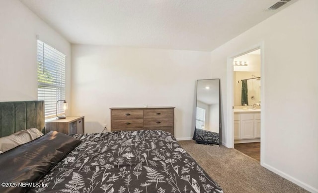 bedroom with carpet, connected bathroom, visible vents, and baseboards