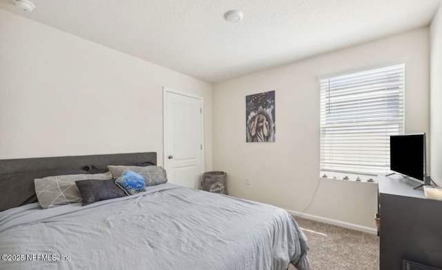 bedroom featuring carpet and baseboards