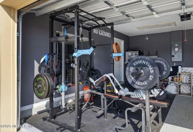 workout room with a garage and electric panel