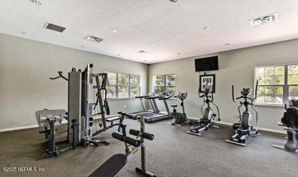 workout area with a healthy amount of sunlight, baseboards, and visible vents