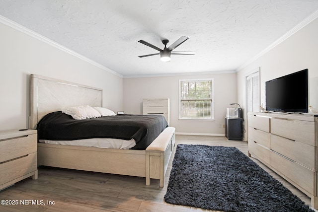 bedroom with a textured ceiling, wood finished floors, a ceiling fan, and crown molding