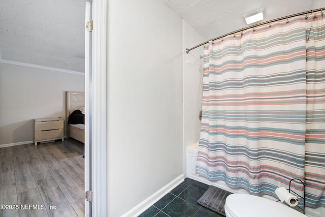 full bath with a textured ceiling, toilet, baseboards, tile patterned floors, and shower / bath combination with curtain