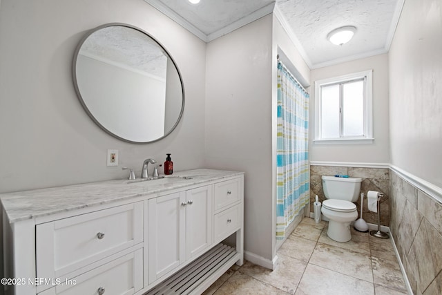 full bathroom with toilet, ornamental molding, a textured ceiling, vanity, and tile walls