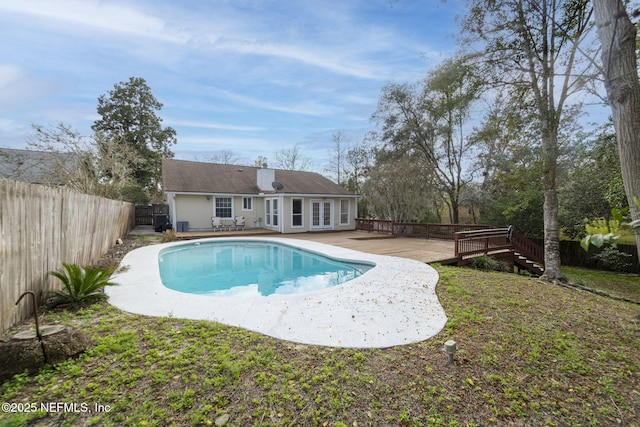 view of swimming pool featuring a fenced in pool, french doors, a patio, a fenced backyard, and a wooden deck