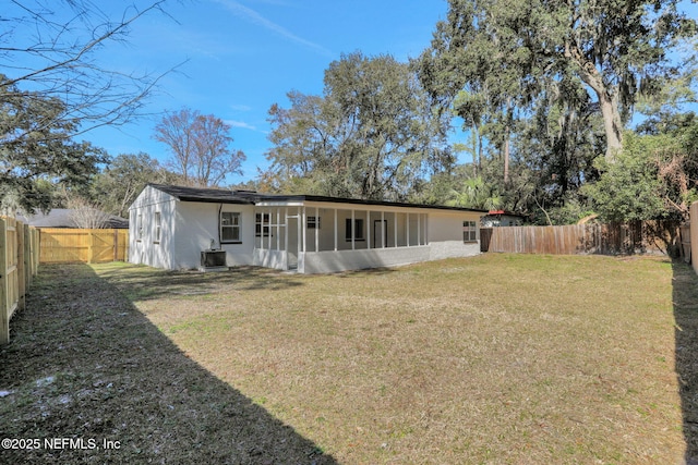 rear view of property with a yard and central air condition unit