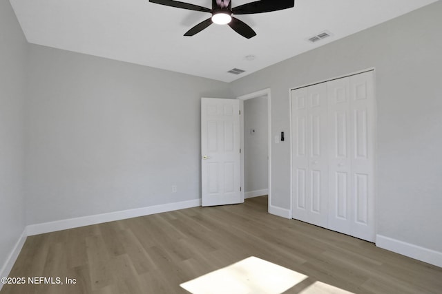 unfurnished bedroom featuring ceiling fan, light wood-type flooring, and a closet