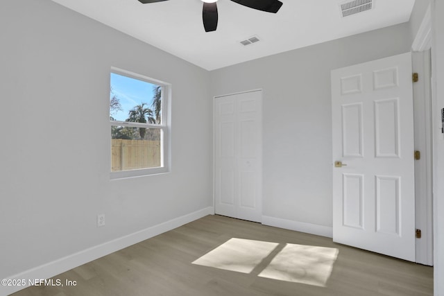 unfurnished bedroom with ceiling fan, light hardwood / wood-style floors, and a closet