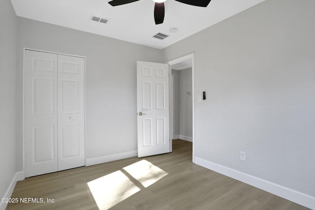 unfurnished bedroom with light hardwood / wood-style floors, a closet, and ceiling fan