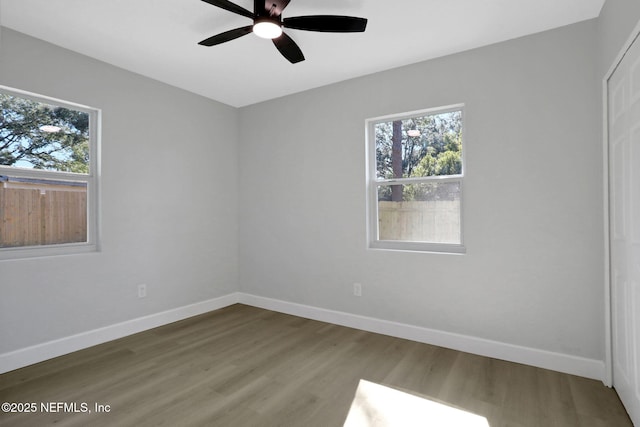 unfurnished room featuring ceiling fan, plenty of natural light, and wood-type flooring