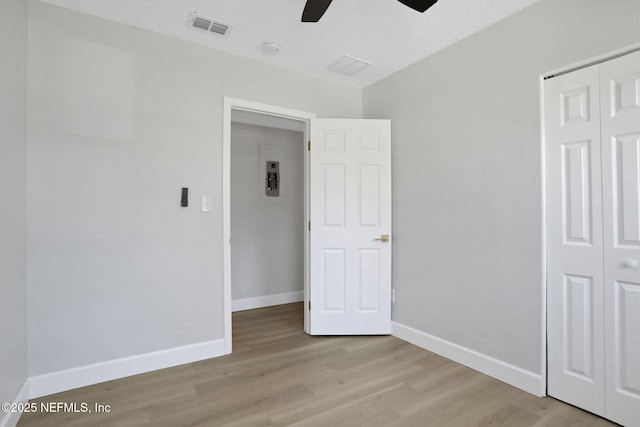 unfurnished bedroom with ceiling fan, light hardwood / wood-style floors, and a closet