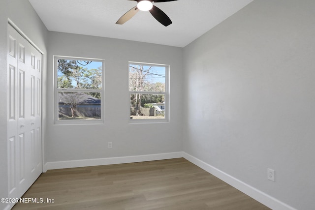 unfurnished bedroom featuring wood-type flooring, a closet, and ceiling fan