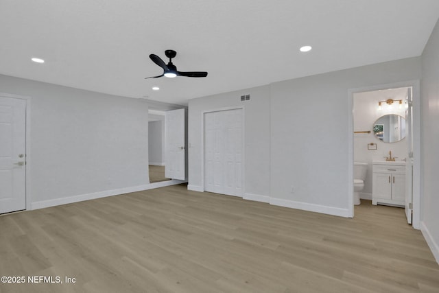 unfurnished bedroom with ensuite bathroom, sink, light hardwood / wood-style floors, and a closet