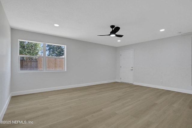 spare room with ceiling fan and light wood-type flooring