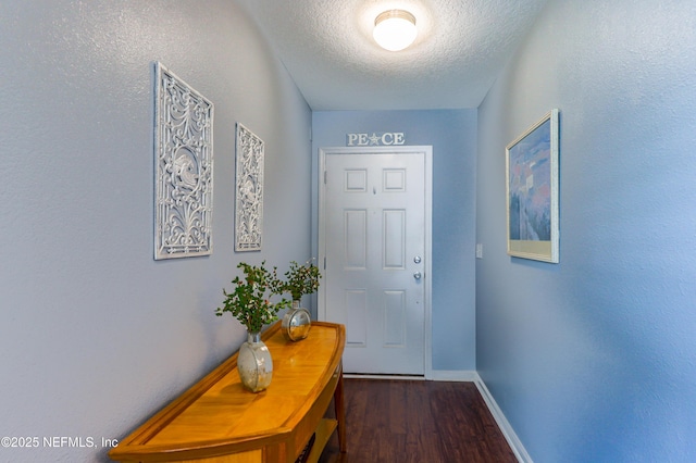 doorway to outside with dark hardwood / wood-style floors and a textured ceiling