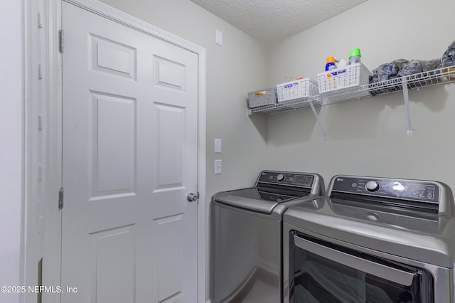 washroom with separate washer and dryer and a textured ceiling