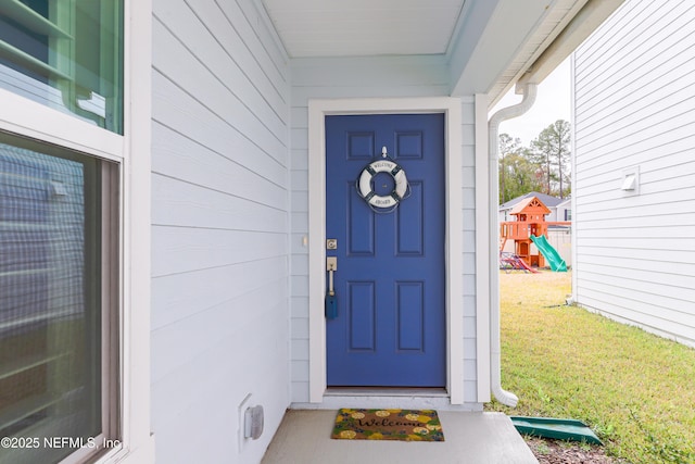 property entrance featuring a lawn