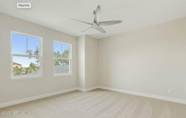 spare room with ceiling fan and light colored carpet