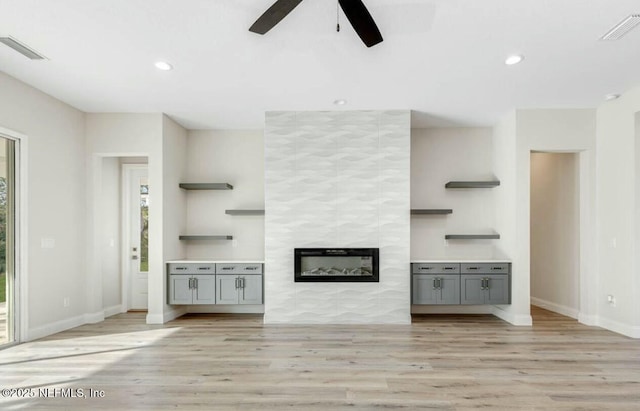 unfurnished living room with a fireplace, light hardwood / wood-style floors, and ceiling fan