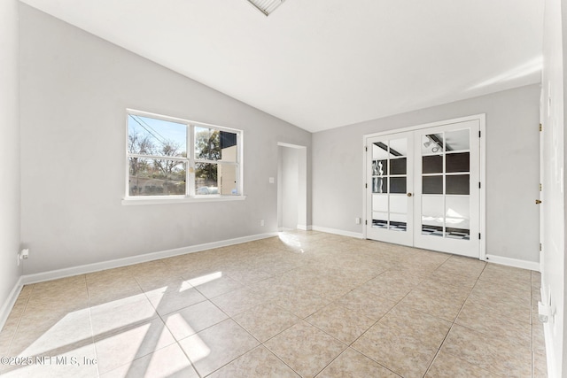 tiled spare room with vaulted ceiling and french doors