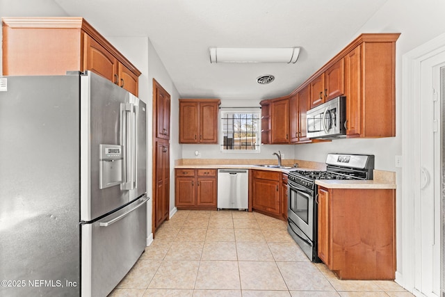 kitchen featuring light tile patterned flooring, appliances with stainless steel finishes, and sink