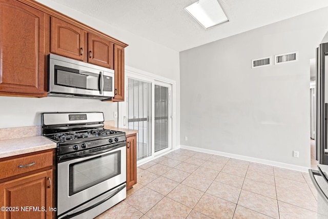 kitchen with light tile patterned floors and appliances with stainless steel finishes