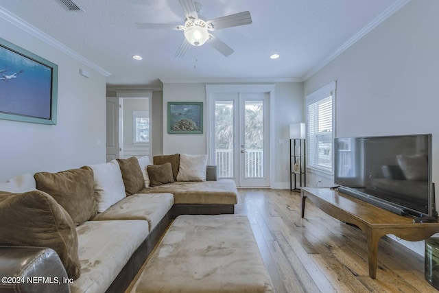 living room featuring ornamental molding, light hardwood / wood-style floors, and ceiling fan