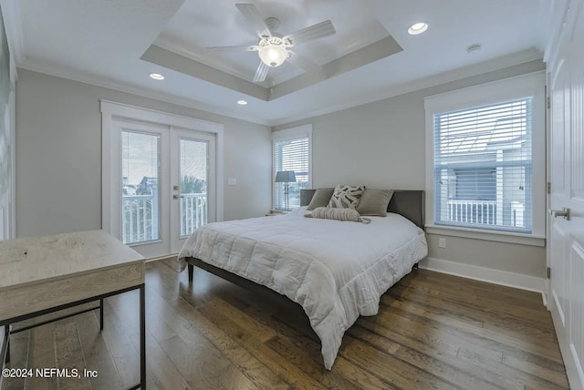 bedroom with dark hardwood / wood-style flooring, ornamental molding, access to outside, a tray ceiling, and french doors