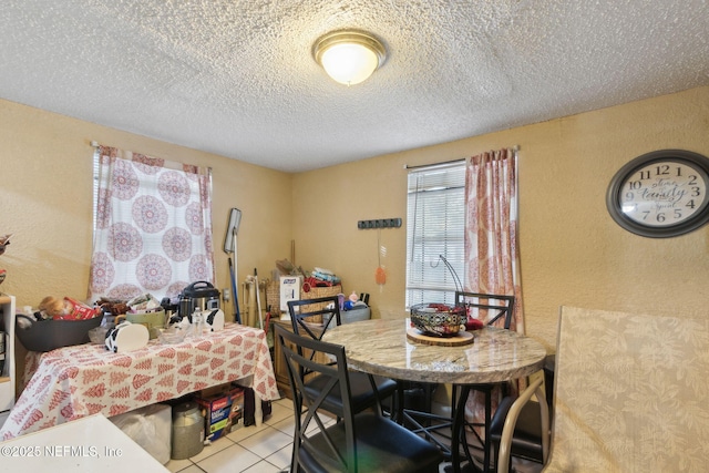 dining space with light tile patterned floors and a textured ceiling