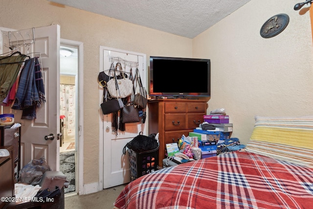 bedroom featuring lofted ceiling and a textured ceiling