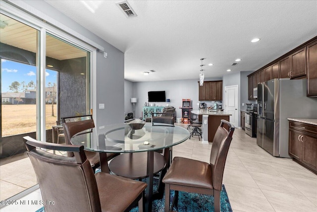 dining space featuring light tile patterned floors and a textured ceiling