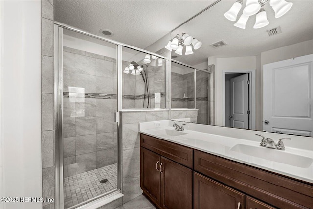 bathroom featuring vanity, an enclosed shower, and a textured ceiling