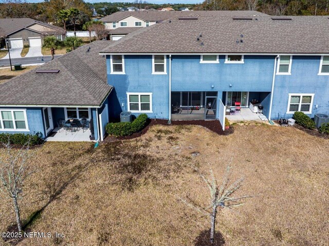 rear view of house with a yard, central AC unit, and a patio