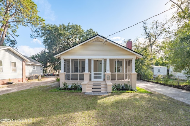 bungalow with a sunroom and a front yard