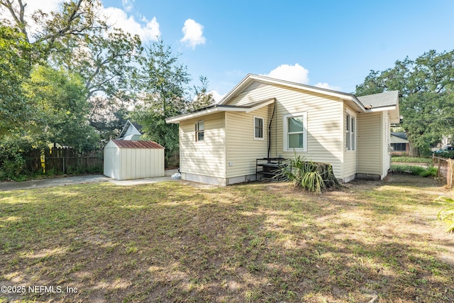 back of house featuring a storage unit and a yard